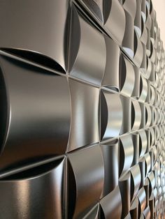 a close up view of a wall made out of black metal sheets with wavy shapes