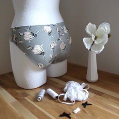 there are two vases with flowers on the table next to each other and one is wearing a diaper