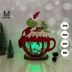 the grin's teapot is lit up with green light and features an image of a christmas tree