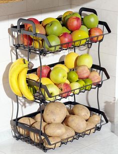 two tiered metal fruit rack with potatoes and apples