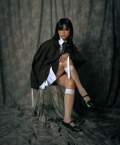 a woman sitting on top of a chair wearing stockings