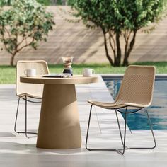 two chairs and a table near a pool