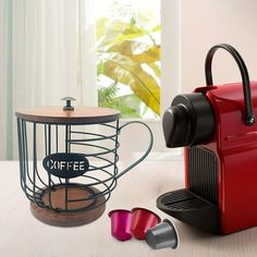 a red coffee maker sitting on top of a wooden table