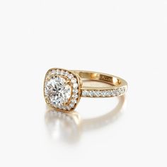 a yellow gold ring with diamonds on the sides and a center stone in the middle