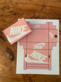 two nike boxes sitting on top of a wooden table