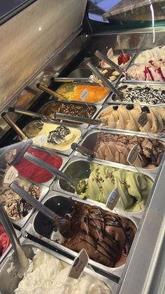 an assortment of ice creams and desserts on display in a buffet area at a restaurant