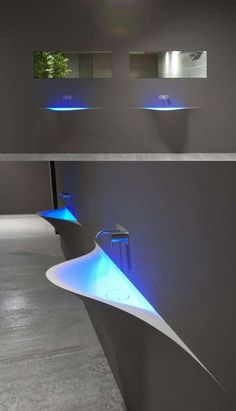 two sinks with blue lights on them in a room