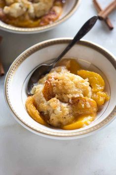 two bowls filled with food on top of a white counter next to an apple pie