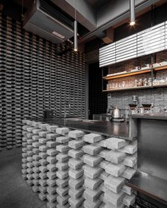 an industrial style bar with stacks of concrete blocks on the counter and shelves behind it