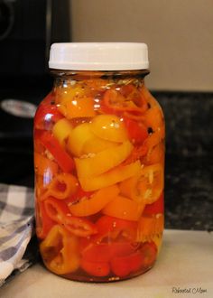 a jar filled with sliced bell peppers on top of a counter