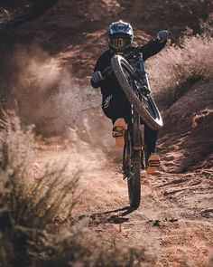 a man riding a bike down a dirt road