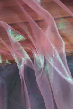 an abstract photograph of pink sheer fabric