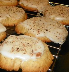 cookies with white icing and cinnamon sprinkles are cooling on a rack