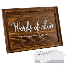 a wooden sign that says words of love or memories to share on it with two cards