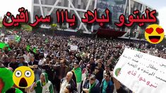 a large group of people holding signs in front of a building with red and green flags