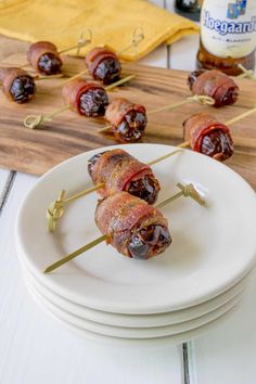 bacon wrapped dates on skewers are ready to be served with beer and mustard