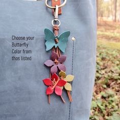 a keychain that has flowers on it and the words choose your butterfly color from those listed