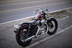 a motorcycle is parked on the side of the road in front of an empty street