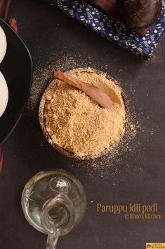 some food is sitting on a table next to a wine glass and a wooden spoon