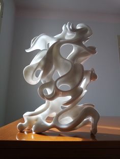 a white sculpture sitting on top of a wooden table