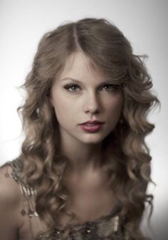 a woman with long curly hair wearing a dress