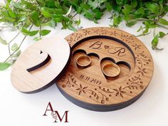 two wooden wedding rings are in the shape of a ring box, and one is on top of another