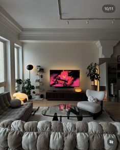 a living room filled with furniture and a large flat screen tv mounted on the wall