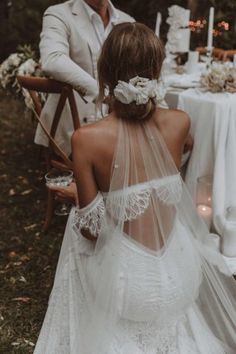 the back of a bride's dress as she sits at a table