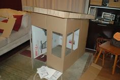 a cardboard doll house sitting on top of a rug