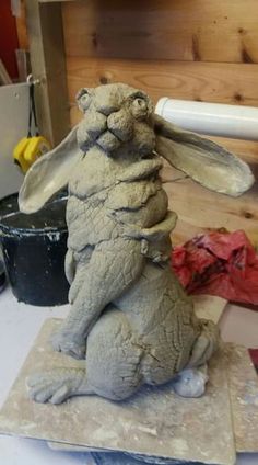 a clay sculpture of a rabbit sitting on top of a table