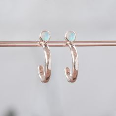 Custom Opal Birthstone Hoop Earrings | 14K Rose Gold displayed on holding bar. Honor Yourself, Staple Earrings, Opal Birthstone, White Gold Set, Metal Texture, Salt And Pepper Diamond, Stone Cuts, Gold Hoops, White Rose Gold