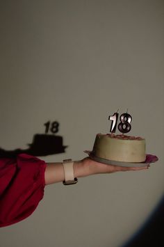 a person holding a cake with the number thirteen on it