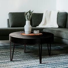 a living room with a couch, coffee table and rug