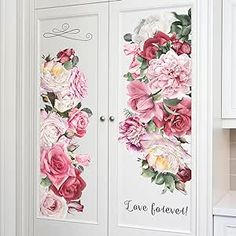 two doors with flowers painted on them in a white kitchen, next to a sink