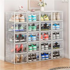 a stacking rack filled with lots of pairs of shoes on top of a hard wood floor