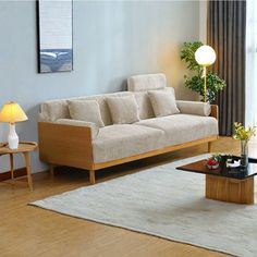 a living room filled with furniture next to a large glass window and wooden flooring