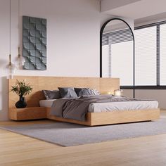 a large bed sitting on top of a hard wood floor next to a tall window