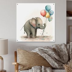 an elephant with balloons in its trunk on the wall next to a couch and lamp