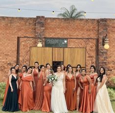 a group of women standing next to each other in front of a brick building with lights