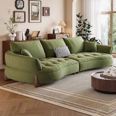 a living room with green couches and pictures on the wall above it, along with a coffee table