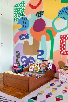 a brightly colored room with a bed and colorful artwork on the wall