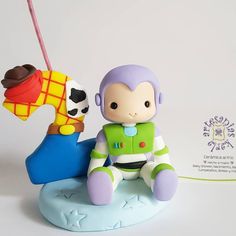 a toy figurine sitting on top of a blue horse next to a cow