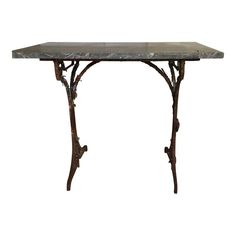 an iron table with marble top and metal legs