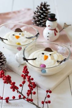 two bowls filled with snowman pudding on top of a table