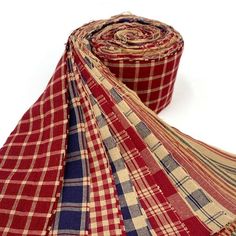 red, white and blue plaid fabric rolled on top of each other