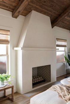 a living room with a fire place next to a window and a couch in front of it