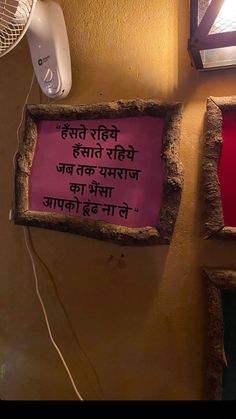 a pink sign hanging on the side of a wall next to an air conditioner