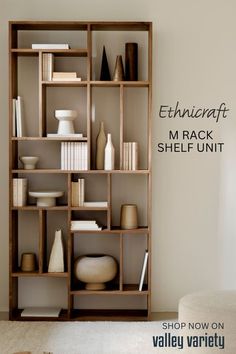 a shelf filled with vases and books on top of a white carpeted floor