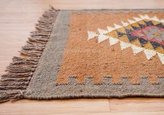 a close up of a rug on a wooden floor