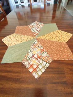 a wooden table topped with lots of different colored pieces of fabric on top of it